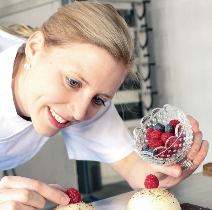 Stefanie Denninger vom Schloss Montfort dekoriert ein Törtchen mit Früchten